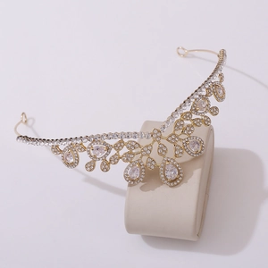 Close-up of golden bridal tiara with sparkling pear-cut crystals on a neutral base