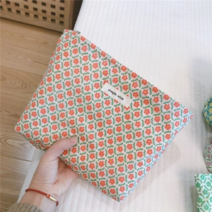 Close-up of small floral cotton makeup bag with red flower prints and zipper detail
