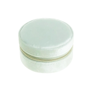 Close-up of mint green velvet round jewelry box with a smooth metal zipper closure
