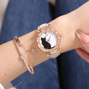 Detail shot of a rose gold cat pattern watch and star charm bracelet set on denim background