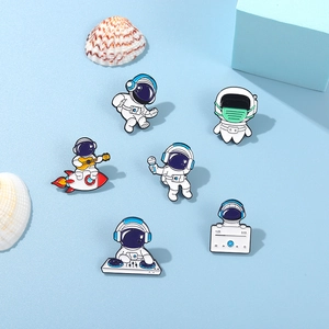 Detailed close-up of six astronaut enamel pins featuring music and space themes on blue base
