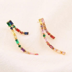 Detail of gold earrings with curved rows of multi-colored rectangular cubic zirconia stones