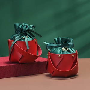 Detail eines roten Weihnachtsgeschenkkorb aus Leder mit grünem Beutel und Goldnieten