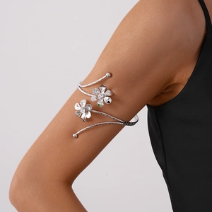 Detail view of a silver floral upper arm cuff with spiral design and crystal-set petals