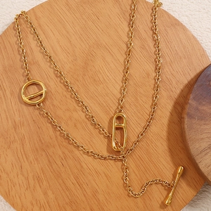 Minimalist gold stainless steel pig nose chain necklace with OT buckle on wooden tray