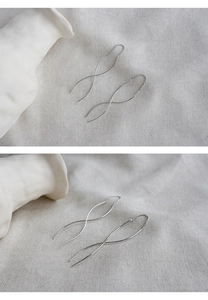 Detail of S925 sterling silver S-shaped threader earrings with wavy metallic lines