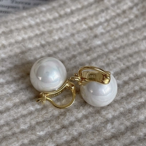 Detailed macro view of S925 sterling silver hallmark on golden pearl earring clasp