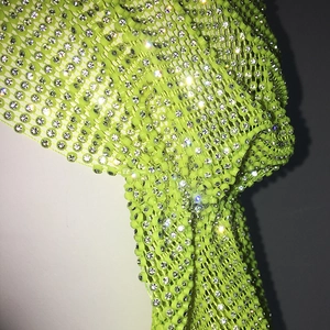 Macro shot of neon green mesh with sparkling crystal rhinestones for nightwear accessories