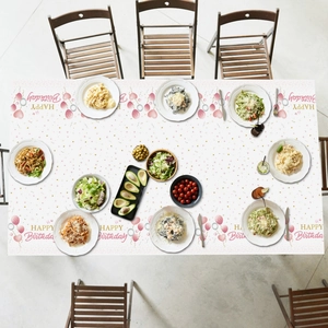 Detailed top view of a pink Happy Birthday tablecloth with balloons and party food