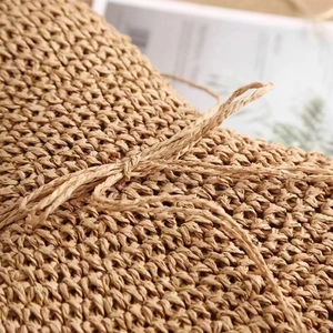Handwoven straw hat featuring a detailed bow decoration and natural textured material
