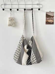 Detail of canvas tote bag featuring black and white polka dots and stripes patchwork pattern