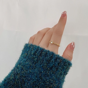 INS style chain ring with a square-cut zircon stone on a model's hand wearing green sweater