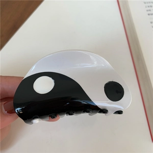 Detail of yin yang hair claw clip made of polished acrylic with smooth edges and black white finish