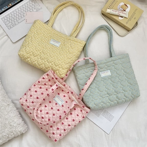 Gros plan de sacs cabas matelassés avec motifs cœurs et textures de tissu à carreaux