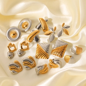 Elegant gold and silver dual-tone geometric stainless steel earrings on satin background