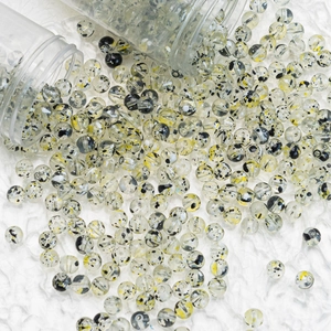 Macro shot of 8mm transparent glass flower beads with black and yellow spots for DIY jewelry
