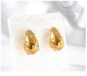 Detailed view of gold-plated teardrop earrings with pavé set sparkling crystals