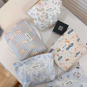 Flat lay view of cotton canvas pouches with cute cartoon prints and zip closure