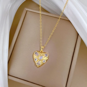 Detailed shot of a gold heart-shaped pendant necklace with sparkling gems in a gift box