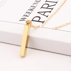 Minimalist gold stainless steel vertical bar pendant necklace on elegant book background