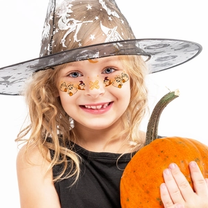 Close-up of Halloween face stickers on a child with ghost and pumpkin motifs