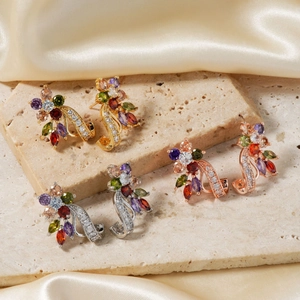 Detailed view of flower stud earrings in gold, silver, and rose gold with multi-colored stones