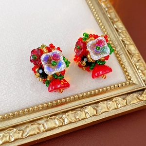 Macro shot of colorful beaded flower earrings on a vintage gold frame background