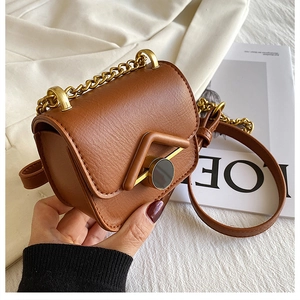 Dettaglio di una mini borsa a tracolla vintage marrone con patta a V e catena dorata