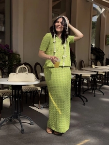 Women's green crochet knit polo and maxi skirt set shown in a stylish outdoor setting