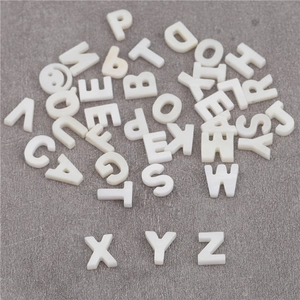 Macro dettagliata di perline a conchiglia bianca con lettere X Y Z e motivi a sorriso