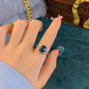 Luxury royal blue sapphire engagement ring with oval halo design and gold band