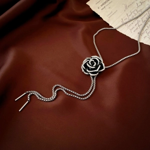 Detail of vintage black rose pendant with sparkling zircons on a silver snake chain