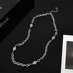 Titanium steel necklace with rhombus charms and O-chain links on dark reflective surface
