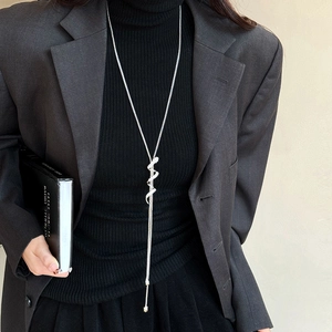 Silver Y-shaped snake pendant necklace worn with professional suit for a minimalist style