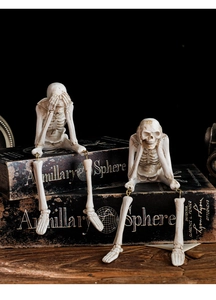 Detailansicht der Skelettfiguren aus Harz mit beweglichen Metallbeinen auf Vintage-Büchern