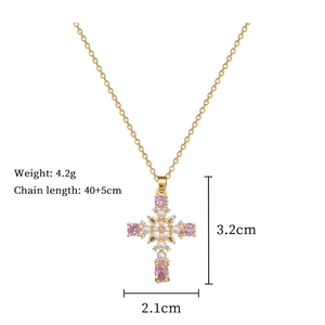 Detailed view of titanium steel cross pendant with pink stones, pearls, and crystals