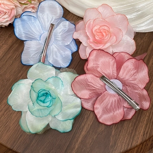 Detail of colorful fabric flower hair clips with layered mesh petals and metal duckbill grip