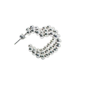 Macro shot of silver C-shaped earrings with layered spherical beads for a modern textured look