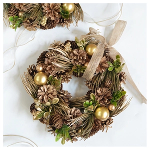 Detail of Christmas wreath with vintage gold pinecones, baubles and burlap ribbon