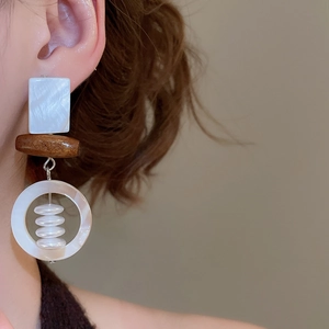 Detail of square shell and wood bead earrings with white pearls on a female model