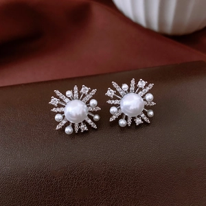 Detailed close-up of 18k gold plated flower stud earrings with pearls and zircon stones
