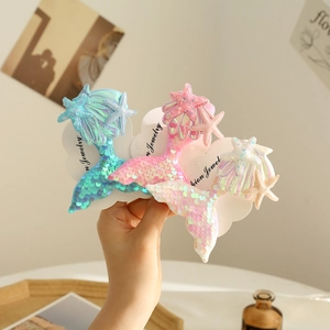 Close-up of sparkling sequin mermaid tail hair clips with starfish in blue, pink, and white