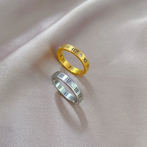 Minimalist titanium steel Roman numeral ring with single zircon on champagne silk fabric