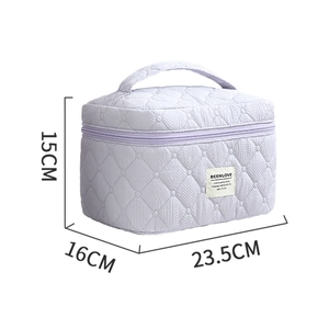 Quilted lavender cosmetic bag with handle and dimensions 23.5 x 16 x 15 cm on white background
