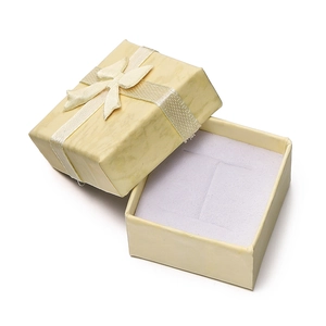 Detailed close-up of a square beige jewelry gift box with a silk bow and sponge insert