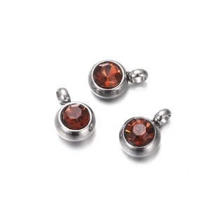 Detailed view of silver stainless steel earring charms with faceted brown zircon gemstones