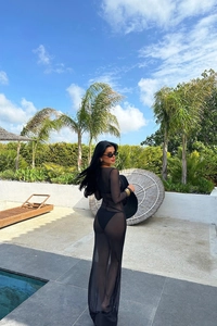 Détail d'une robe de plage longue en tulle noir transparent avec maillot au bord
