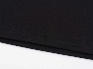 Macro shot of double-needle stitching on the hem of this black cotton knit T-shirt