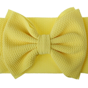Infant wide waffle knit headband featuring a large yellow bow on white background