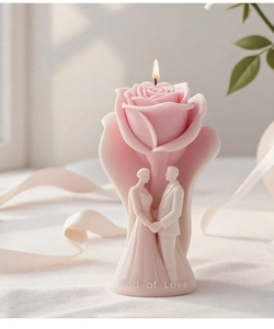 Macro shot of rose candle atop a wedding couple base with God of Love relief